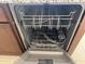 A stainless steel dishwasher with an open door is surrounded by brown cabinets at 7046 N 84Th Dr, Glendale, AZ 85305