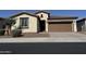 Charming single-story home featuring desert landscaping, a brown garage door, and a tile roof at 7046 N 84Th Dr, Glendale, AZ 85305
