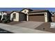 Charming single-story home featuring desert landscaping, a brown garage door, and a tile roof at 7046 N 84Th Dr, Glendale, AZ 85305