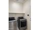 Well-lit laundry area equipped with modern front-load washer and dryer units and built in shelf at 7046 N 84Th Dr, Glendale, AZ 85305