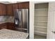 A walk-in pantry with plenty of shelving sits right next to a stainless steel refrigerator at 7046 N 84Th Dr, Glendale, AZ 85305