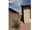 View of the side yard with crushed gravel, brick wall, and a small palm tree at 7046 N 84Th Dr, Glendale, AZ 85305