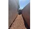 Narrow side yard with gravel, an air conditioning unit, and a view of the neighborhood at 7046 N 84Th Dr, Glendale, AZ 85305