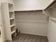 Walk-in closet with neutral carpet, white shelves, and wooden bar for hangers at 7046 N 84Th Dr, Glendale, AZ 85305