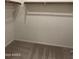 Walk-in closet with neutral carpet, shelves, and wooden bar for hangers at 7046 N 84Th Dr, Glendale, AZ 85305