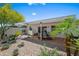 Inviting backyard with a tiled patio, dining set, desert landscaping, and vibrant flowering trees at 7630 E Pasadena Ave, Scottsdale, AZ 85250