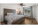 A spacious bedroom showcases natural light, wood-look flooring, and a comfortable bed with stylish decor at 7630 E Pasadena Ave, Scottsdale, AZ 85250