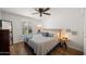 This cozy bedroom features wood floors, a ceiling fan, and a window with natural light at 7630 E Pasadena Ave, Scottsdale, AZ 85250