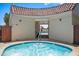 Inviting hot tub with tile accents, a covered entrance, and a glimpse of the community pool beyond at 7630 E Pasadena Ave, Scottsdale, AZ 85250