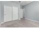 A bedroom with a neutral carpet and a closet with white sliding doors is brightly lit at 7824 S 33Rd Ln, Laveen, AZ 85339