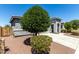 Landscaped front yard with mature tree, decorative rock, and well-maintained exterior at 7824 S 33Rd Ln, Laveen, AZ 85339