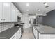 Bright kitchen with white cabinets, gray countertops, stainless steel appliances, and a large island with pendant lights at 7824 S 33Rd Ln, Laveen, AZ 85339