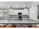 A stylish kitchen features a large island with a sink, pendant lighting, white cabinets, and elegant backsplash at 7824 S 33Rd Ln, Laveen, AZ 85339