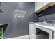Laundry room with modern front load washer and dryer set with light gray walls at 7824 S 33Rd Ln, Laveen, AZ 85339