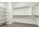 A spacious walk-in closet with white shelving and hanging rods offers ample storage space at 7824 S 33Rd Ln, Laveen, AZ 85339
