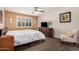 Bright bedroom with wood-look floors, seating area, and a ceiling fan at 8248 E Emelita Ave, Mesa, AZ 85208