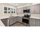 This contemporary kitchen features stainless steel appliances, gray cabinets, and light countertops at 8248 E Emelita Ave, Mesa, AZ 85208