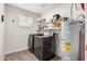 This laundry room features a modern washer and dryer, storage shelves and an efficient water heater at 8248 E Emelita Ave, Mesa, AZ 85208