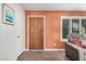 Cozy living room featuring an orange accent wall and hardwood floors at 8248 E Emelita Ave, Mesa, AZ 85208
