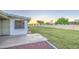 View of the lush backyard with green grass, a concrete patio and block wall at 10620 W Clair Dr, Sun City, AZ 85351