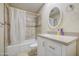 Well-lit bathroom featuring a shower/tub combo, neutral tiling, and a modern vanity at 10620 W Clair Dr, Sun City, AZ 85351