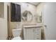 Cozy bathroom with dark cabinets, a mirror, and a toilet at 10620 W Clair Dr, Sun City, AZ 85351