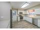 Modern kitchen features stainless steel appliances, white cabinetry, updated countertops and stylish flooring at 10620 W Clair Dr, Sun City, AZ 85351