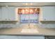 Close-up of kitchen sink area with stylish faucet, white cabinets, and a window letting in natural light at 10620 W Clair Dr, Sun City, AZ 85351