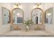 Elegant bathroom with dual sinks, marble countertops, gold fixtures and arched mirrors at 1070 S Amber St, Chandler, AZ 85286
