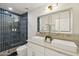 Beautiful bathroom featuring dual sinks, modern gold fixtures, and blue tiled shower with glass door at 1070 S Amber St, Chandler, AZ 85286