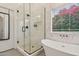 Modern bathroom features glass shower, soaking tub, black hardware and window views at 1070 S Amber St, Chandler, AZ 85286