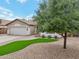 Exterior front view showing a beautifully landscaped yard with a tree, offering shade and curb appeal at 1070 S Amber St, Chandler, AZ 85286