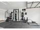 Organized garage gym featuring black rubber flooring and a variety of workout equipment at 1070 S Amber St, Chandler, AZ 85286