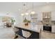 Bright, modern kitchen with a large island, pendant lighting, and stainless steel appliances open to the dining area at 1070 S Amber St, Chandler, AZ 85286