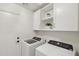Neat laundry room with overhead cabinets and modern, front-load washer and dryer at 1070 S Amber St, Chandler, AZ 85286