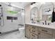 Modern bathroom with dual sink vanity, sleek fixtures, and a glass enclosed shower with a window at 1130 S Surfside Dr, Gilbert, AZ 85233