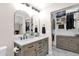 Elegant bathroom with a dual sink vanity, arch mirrors, and a well-organized walk-in closet at 1130 S Surfside Dr, Gilbert, AZ 85233