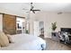 Tranquil primary bedroom featuring a ceiling fan, desk area, and a barn door to the bathroom at 1130 S Surfside Dr, Gilbert, AZ 85233