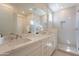 Bright bathroom with double sinks, a white countertop, and a walk-in shower with glass door at 11300 N Casa Dega Dr # 1090, Surprise, AZ 85388