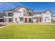 New townhome with manicured lawn, balcony, and modern white facade against a clear blue sky at 11300 N Casa Dega Dr # 1090, Surprise, AZ 85388