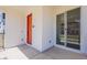Front porch view featuring a modern orange door and large window, perfect for a townhome at 11300 N Casa Dega Dr # 1090, Surprise, AZ 85388