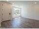 Spacious living room with wood flooring, a large bright window, and fresh neutral paint at 11300 N Casa Dega Dr # 1090, Surprise, AZ 85388