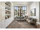 Bright sitting room features built-in shelves, hardwood flooring, and views of manicured landscaping at 11300 N Casa Dega Dr # 1090, Surprise, AZ 85388