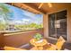 View from the balcony shows mountains, green trees and a table set for outdoor seating at 11500 E Cochise Dr # 2088, Scottsdale, AZ 85259