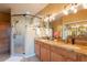 Bathroom featuring double sinks with granite countertops, decorative lighting and glass shower stall at 11500 E Cochise Dr # 2088, Scottsdale, AZ 85259