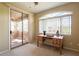 Bedroom features an arched window, work desk and sliding glass doors leading to a patio at 11500 E Cochise Dr # 2088, Scottsdale, AZ 85259
