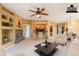 Open living room showcasing a stone fireplace, ceiling fan and barstool seating at the kitchen counter at 11500 E Cochise Dr # 2088, Scottsdale, AZ 85259