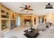 Virtually staged living room featuring a stone fireplace and open access to the kitchen with barstool seating at 11500 E Cochise Dr # 2088, Scottsdale, AZ 85259