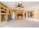 Spacious living room featuring a stone fireplace and open access to the kitchen with barstool seating at 11500 E Cochise Dr # 2088, Scottsdale, AZ 85259