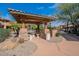 Community outdoor seating area features a covered patio with grill and stone accents at 11500 E Cochise Dr # 2088, Scottsdale, AZ 85259